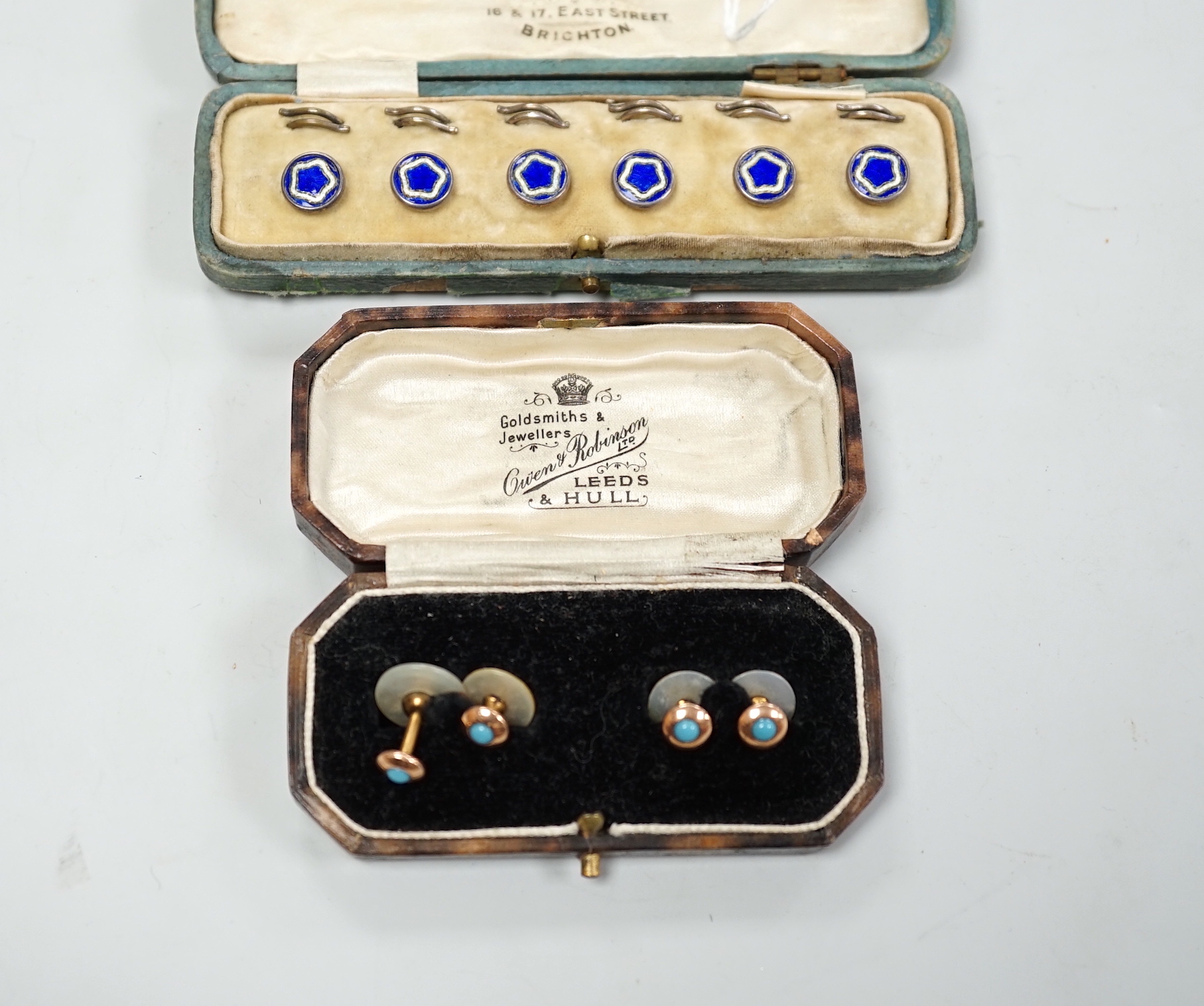 A cased set of six white metal and enamel dress studs and four other dress studs.